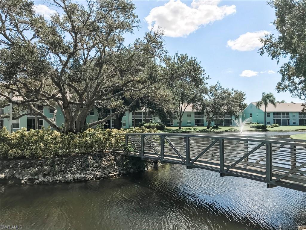 157 Wading Bird Circle, Unit K205 Naples, FL 34110 - Photo 13 of 22 a view of house with lake view and trees in the background