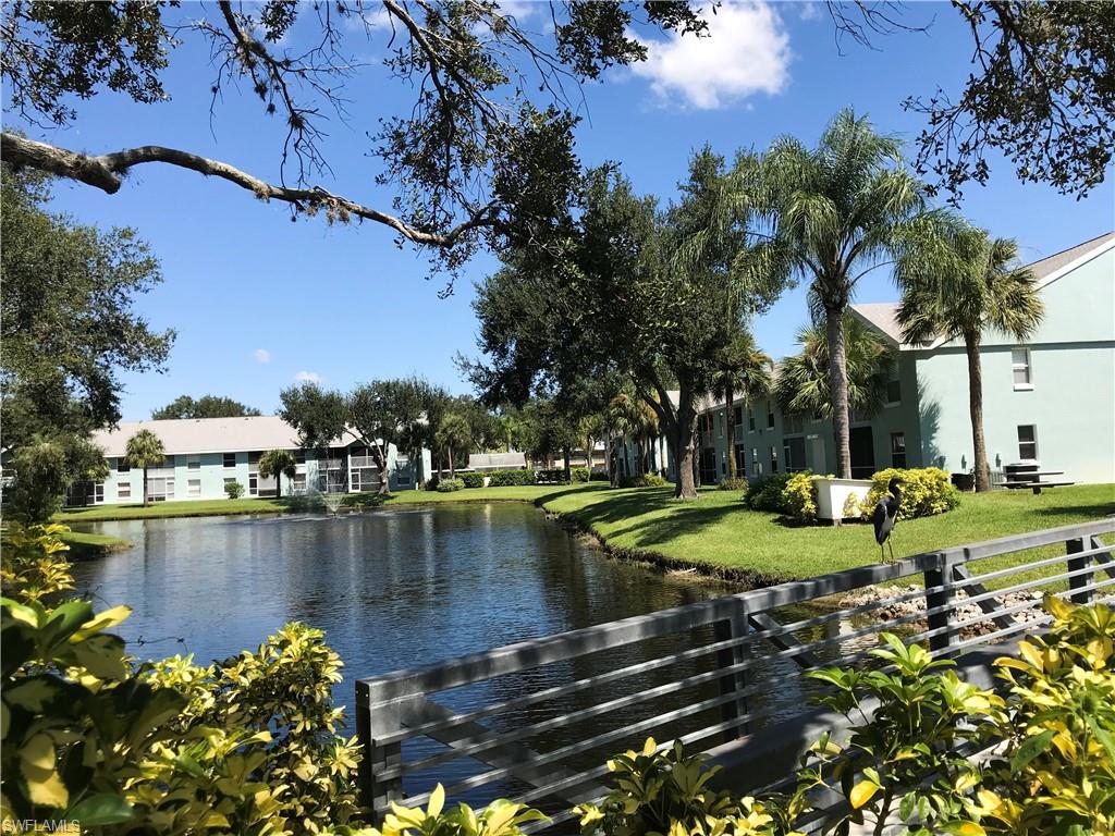 157 Wading Bird Circle, Unit K205 Naples, FL 34110 - Photo 15 of 22 a view of a lake with houses