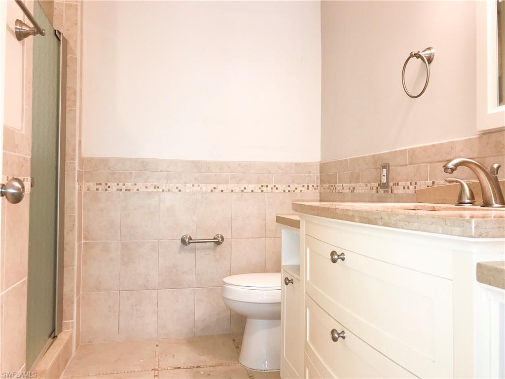 157 Wading Bird Circle, Unit K205 Naples, FL 34110 - Photo 4 of 22 a bathroom with a sink a toilet and shower