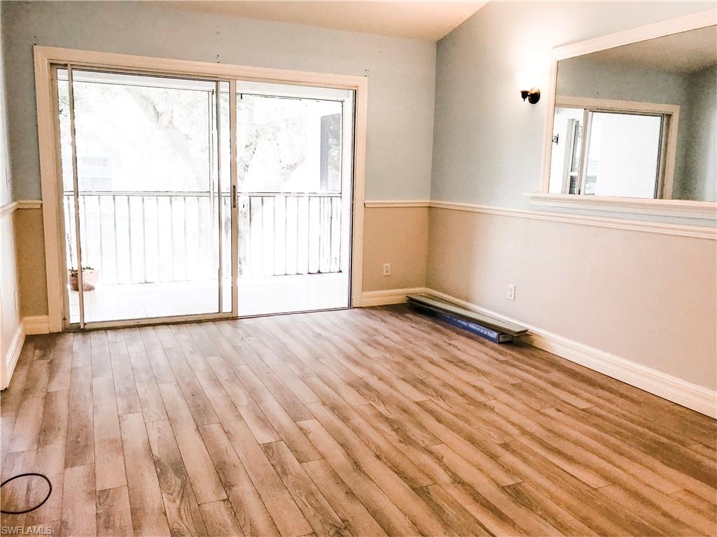157 Wading Bird Circle, Unit K205 Naples, FL 34110 - Photo 5 of 22 an empty room with wooden floor and windows