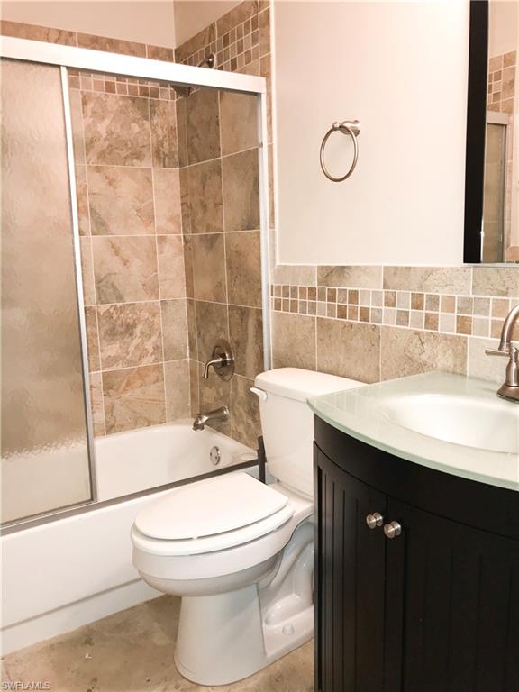 157 Wading Bird Circle, Unit K205 Naples, FL 34110 - Photo 7 of 22 a bathroom with a sink a toilet a mirror and shower