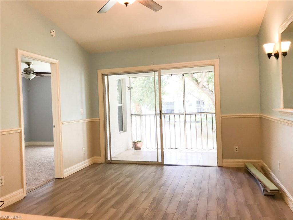 157 Wading Bird Circle, Unit K205 Naples, FL 34110 - Photo 8 of 22 an empty room with wooden floor and windows