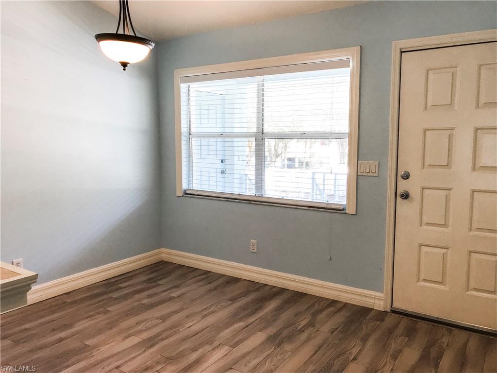 157 Wading Bird Circle, Unit K205 Naples, FL 34110 - Photo 10 of 22 a view of an empty room with wooden floor and a window