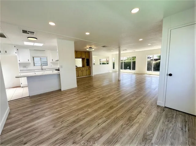 a view of large kitchen with cabinets and wooden floor