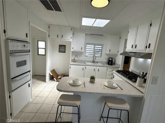 a kitchen with stainless steel appliances a stove a sink and a refrigerator