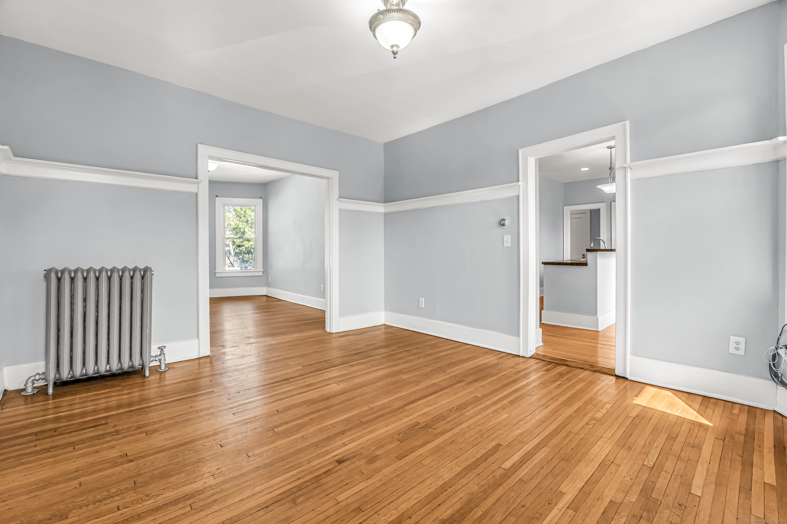 2679 Fairfield Avenue, Unit 2 Bridgeport, CT 06605 - Photo 15 of 22 an empty room with wooden floor and windows
