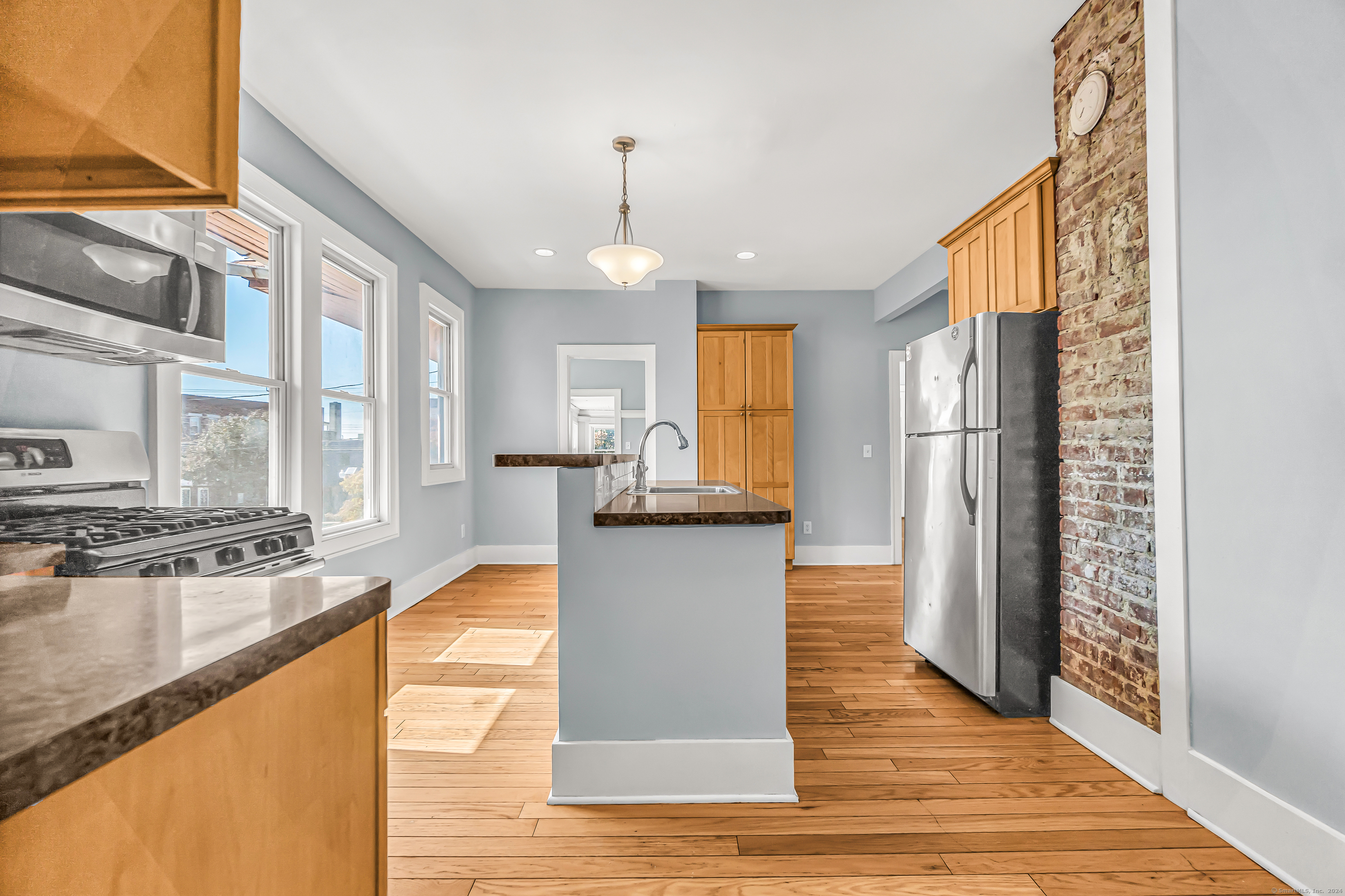 2679 Fairfield Avenue, Unit 2 Bridgeport, CT 06605 - Photo 2 of 22 a large kitchen with stainless steel appliances granite countertop a refrigerator a stove and a wooden floors