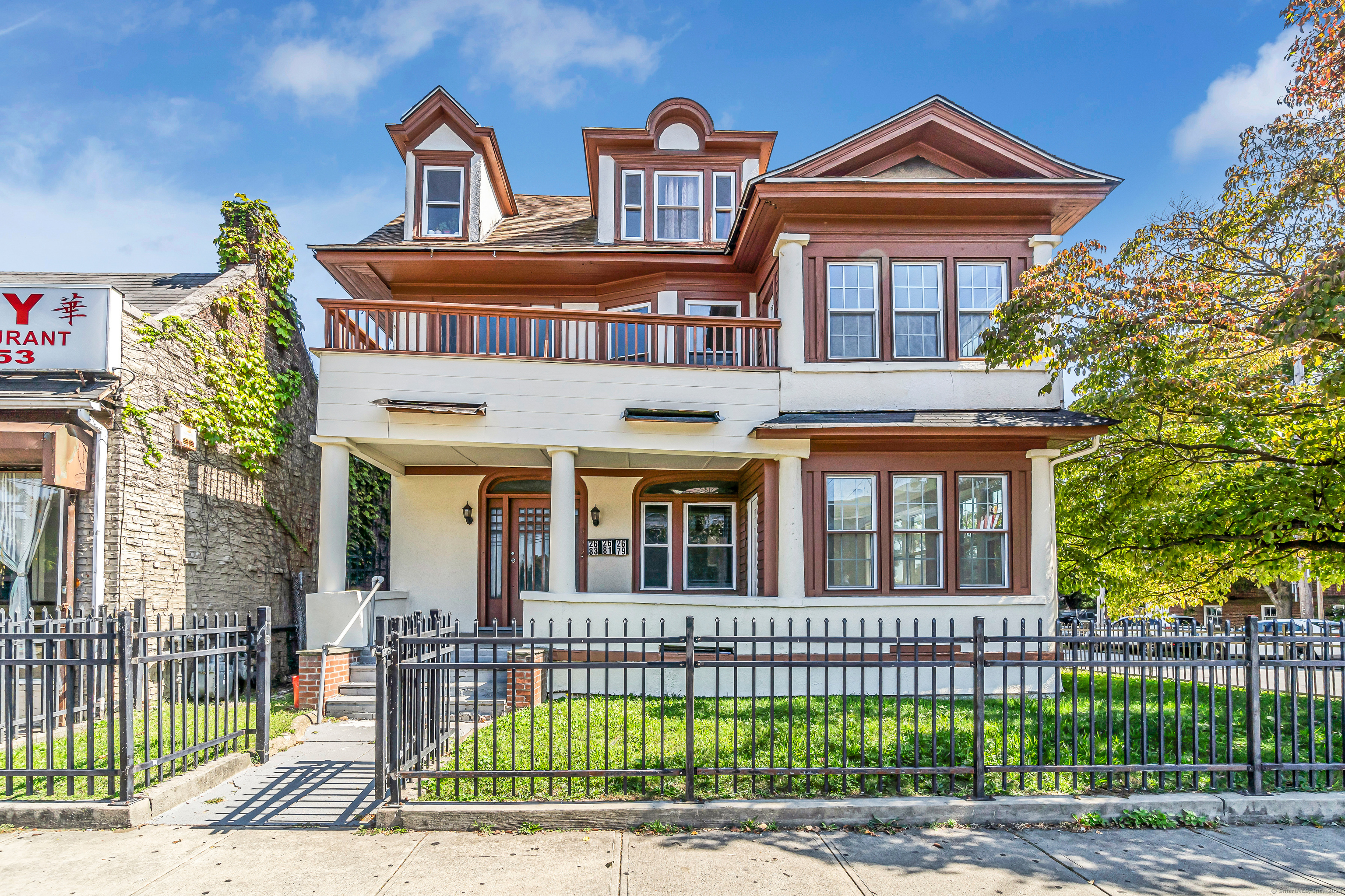 2679 Fairfield Avenue, Unit 2 Bridgeport, CT 06605 - Photo 21 of 22 a view of a brick house with large windows and a small yard
