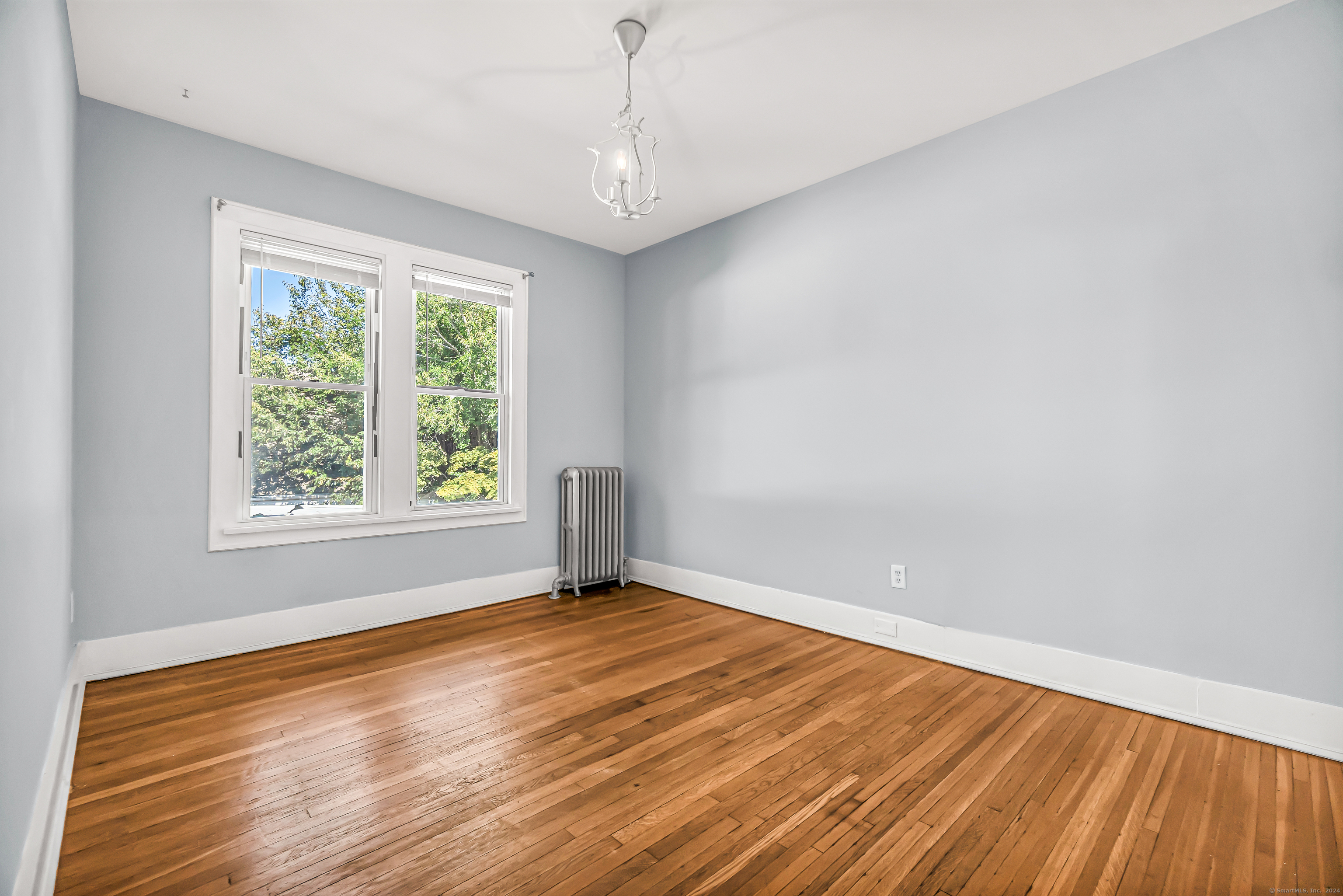 2679 Fairfield Avenue, Unit 2 Bridgeport, CT 06605 - Photo 9 of 22 an empty room with wooden floor and windows