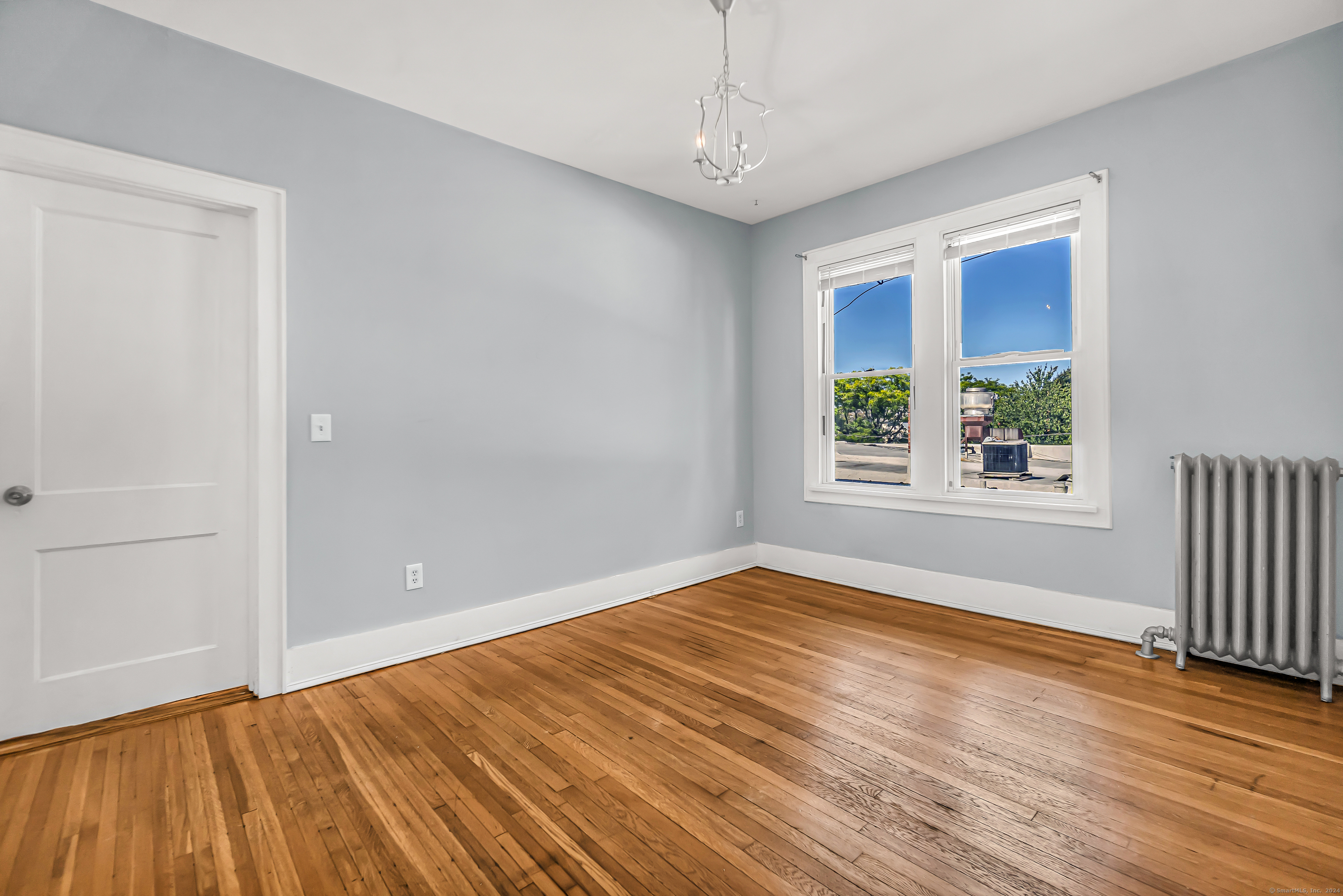 2679 Fairfield Avenue, Unit 2 Bridgeport, CT 06605 - Photo 10 of 22 a view of an empty room with wooden floor and a window