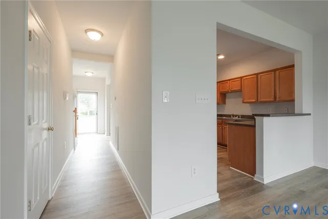 a view of a hallway with wooden floor and a sink