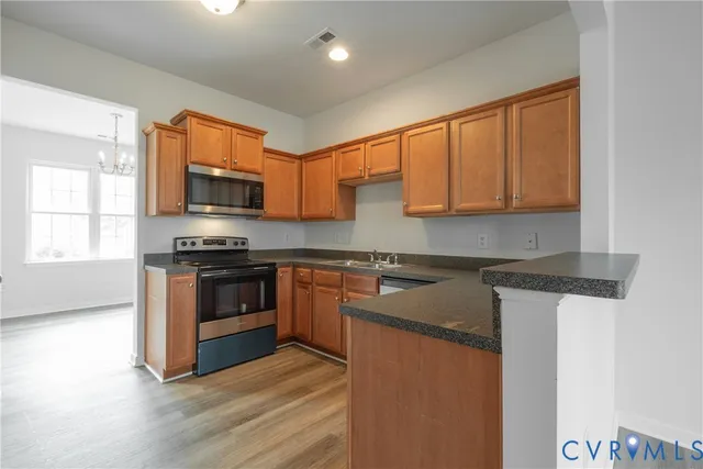 a kitchen with stainless steel appliances granite countertop a stove a sink and a microwave