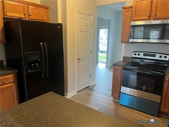 a kitchen with granite countertop a refrigerator stove and microwave