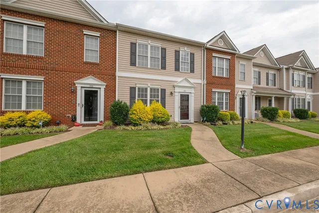 a front view of a house with a garden and plants