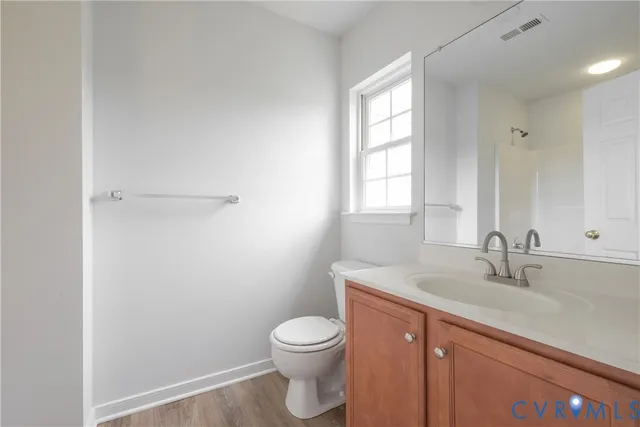 a bathroom with a sink a toilet and a window