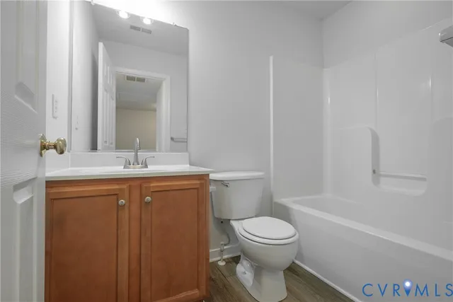 a bathroom with a toilet sink vanity tub and shower