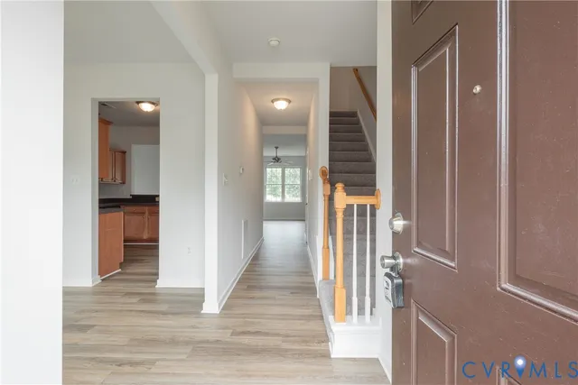 a view of a hallway with wooden floor and staircase