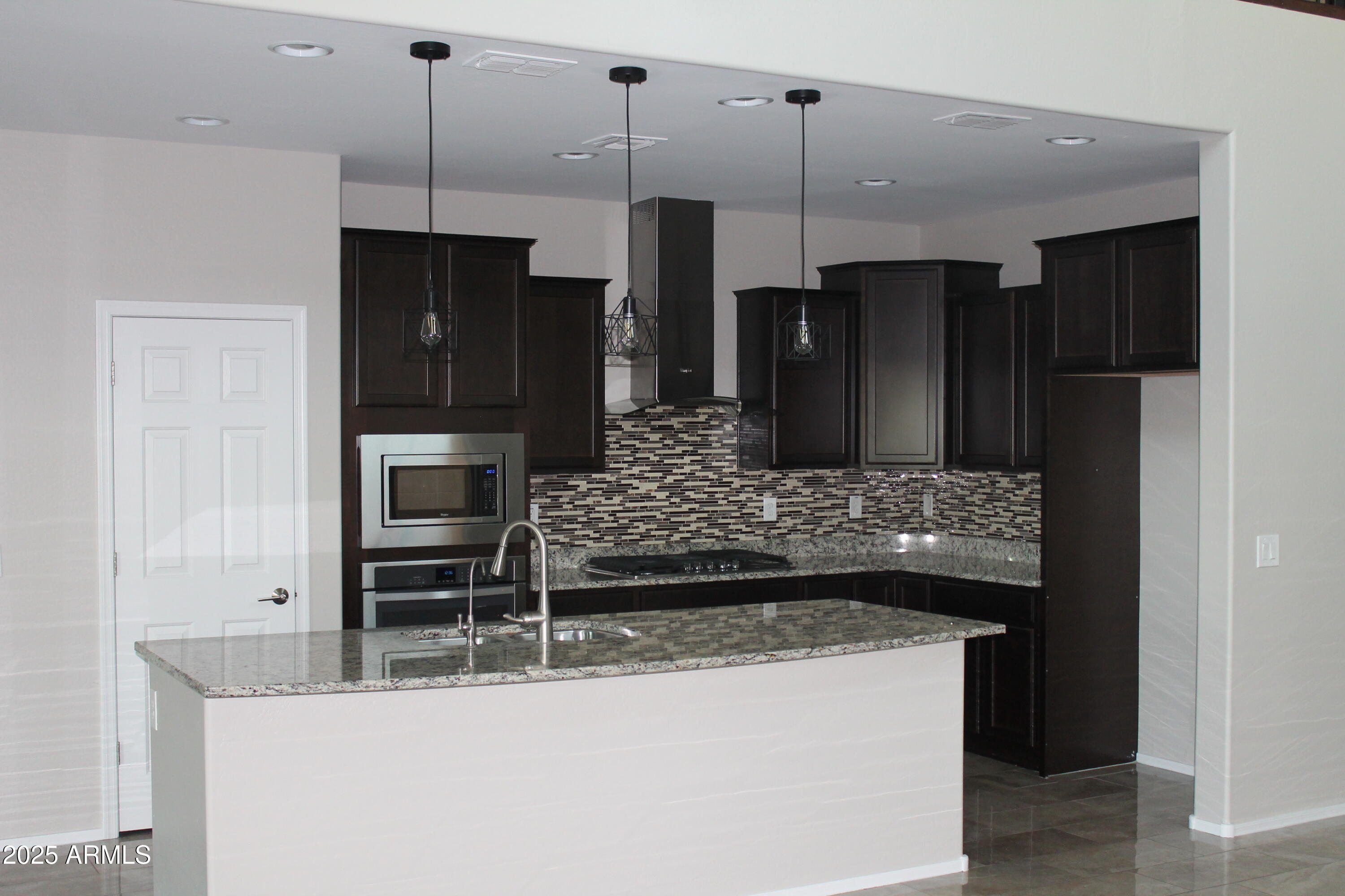 10847 West Nosean Road Peoria, AZ 85383 - Photo 3 of 11 a kitchen with kitchen island a counter top space stainless steel appliances and cabinets