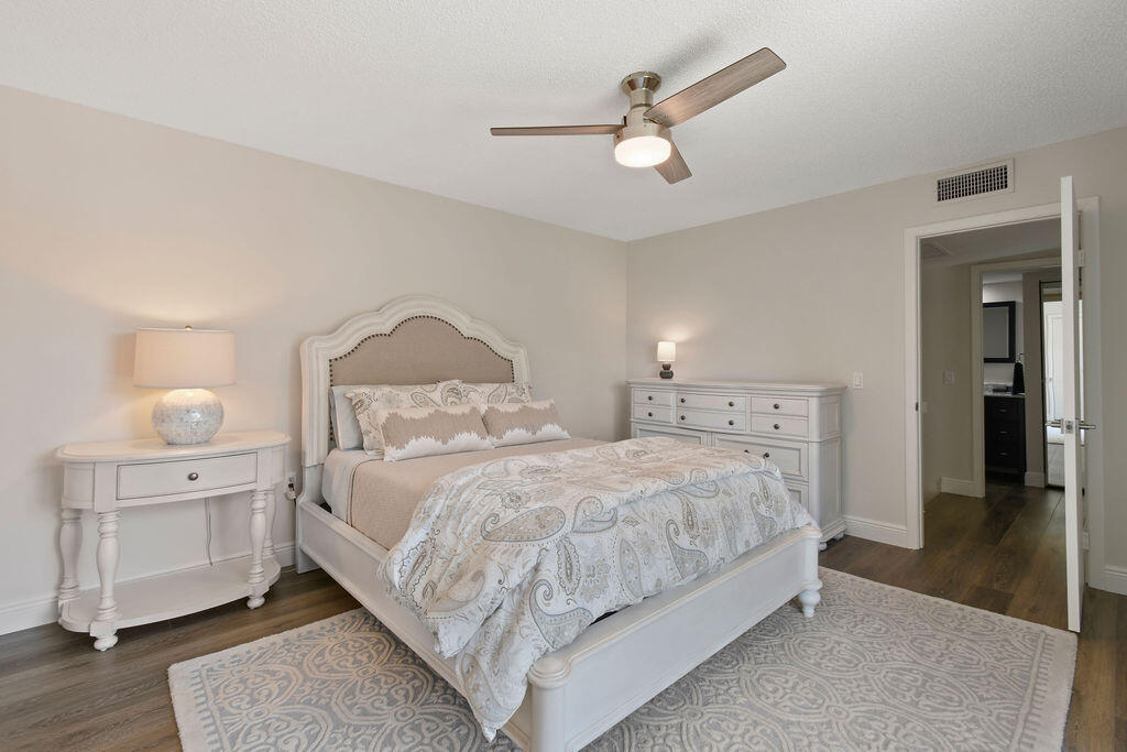 3900 County Line Road, Unit 22A Tequesta, FL 33469 - Photo 12 of 31 a bedroom with a bed and a chandelier
