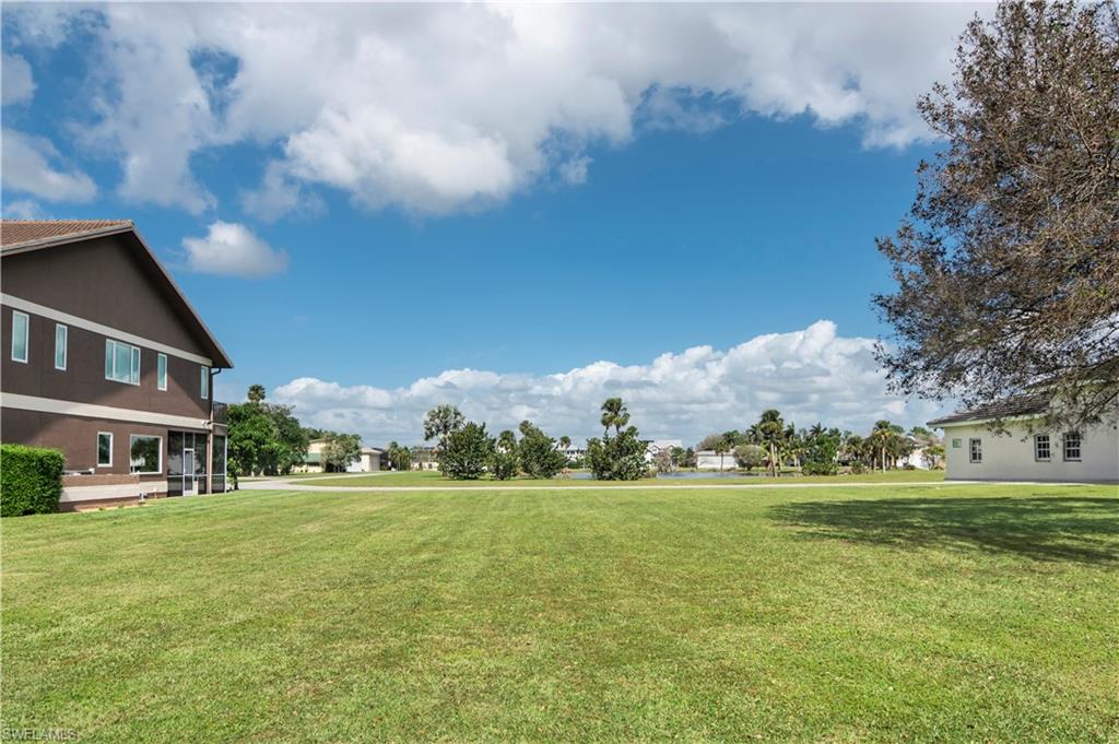 4072 Skyway Drive Naples, FL 34112 - Photo 3 of 11 a view of a building with a big yard and trees