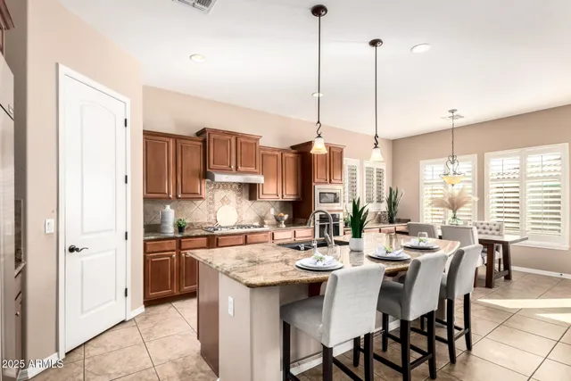 a kitchen with a refrigerator a stove a sink and chairs