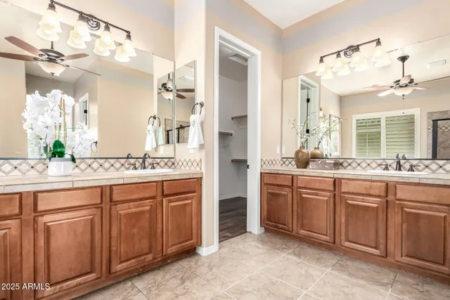 a bathroom with a granite countertop sink mirror bathtub and next to a window