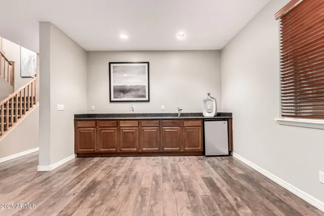 an empty room with wooden floor ceiling fan and windows