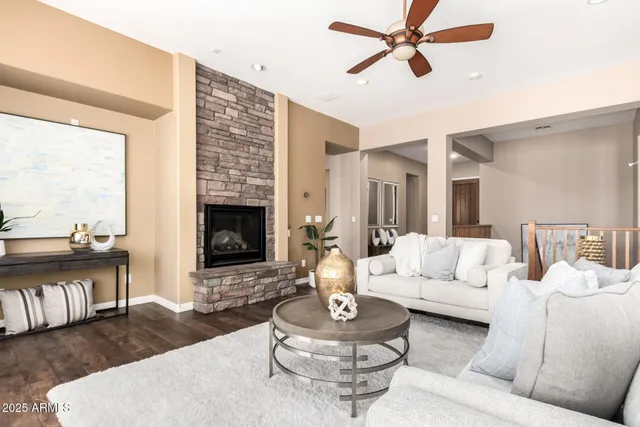 a living room with furniture a fireplace and a large window