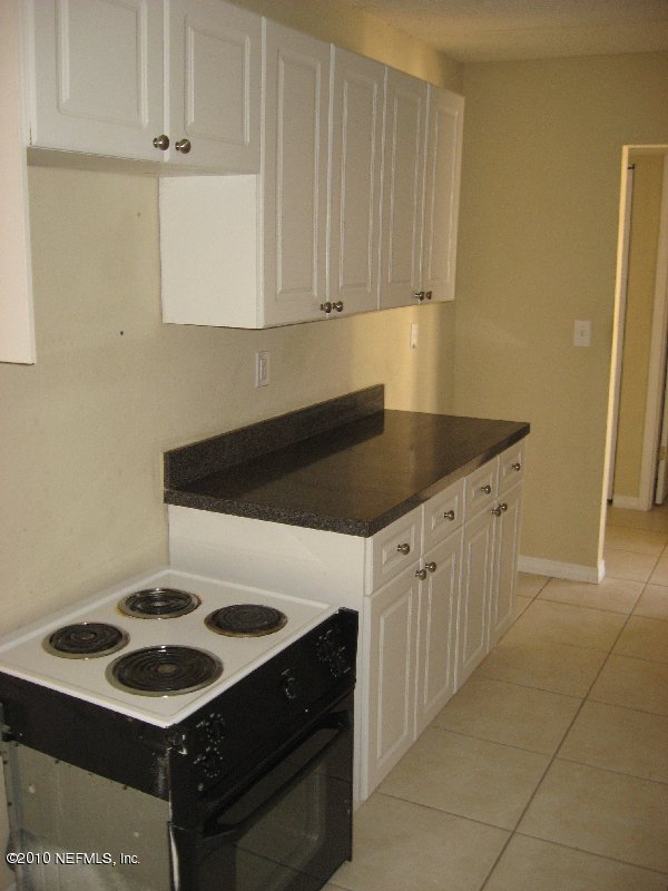 355 Monument Road, Unit 17 D2 Jacksonville, FL 32225 - Photo 4 of 10 a kitchen with granite countertop white cabinets and a stove