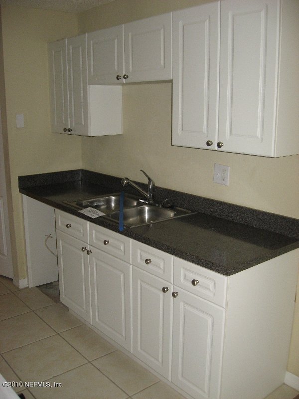 355 Monument Road, Unit 17 D2 Jacksonville, FL 32225 - Photo 5 of 10 a kitchen with granite countertop white cabinets and sink