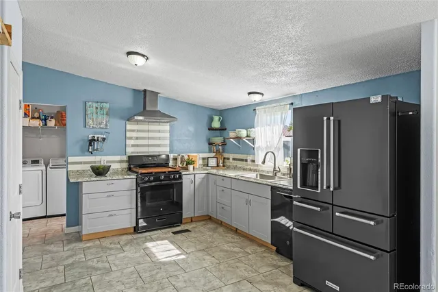 a kitchen with a stove a refrigerator and a sink