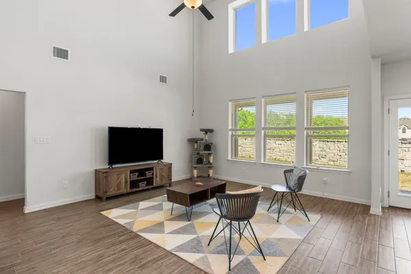 a living room with furniture a flat screen tv and a large window