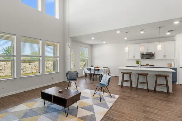 a living room with furniture a wooden floor and kitchen view