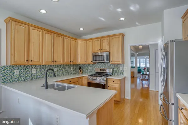 a kitchen with stainless steel appliances granite countertop a sink a stove and cabinets