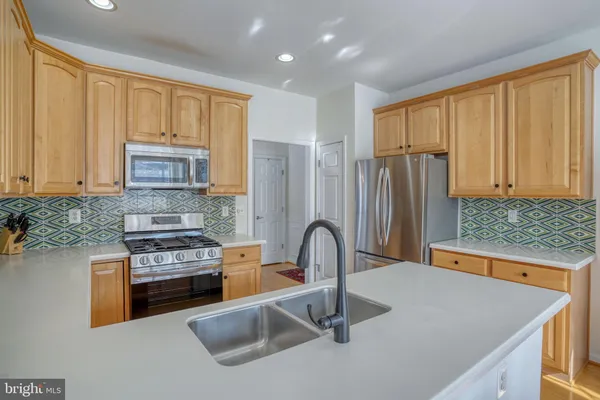 a kitchen with a refrigerator and a stove top oven