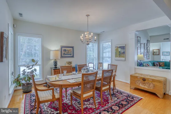a view of a dining room with furniture a chandelier and wooden floor