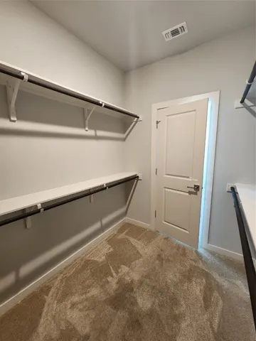 an empty room with a chandelier fan and windows