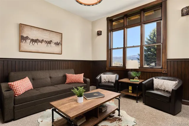 a living room with furniture and floor to ceiling windows