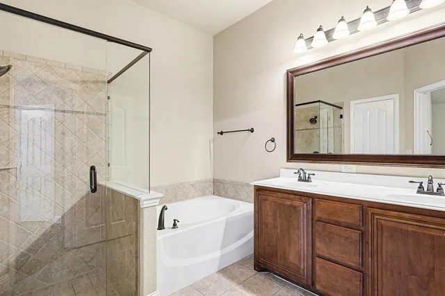 a bathroom with a tub a double vanity sink and mirror