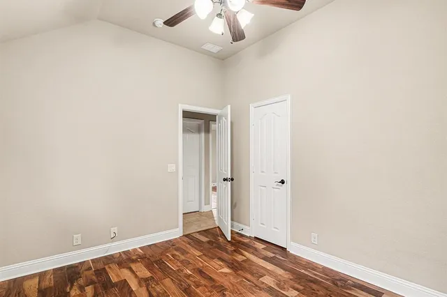 an empty room with a ceiling fan and carpet