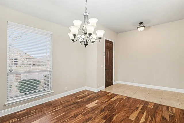 a view of a bedroom with wooden floor and chandelier