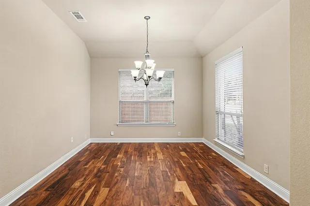 a view of a room with wooden floor and windows
