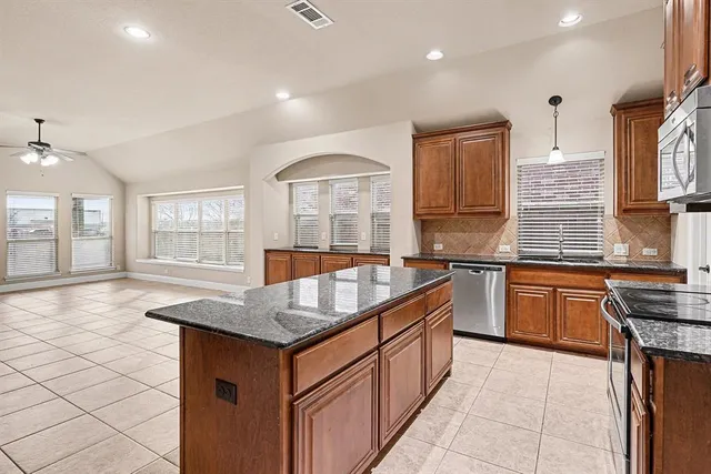 a kitchen with granite countertop a sink stove and cabinets