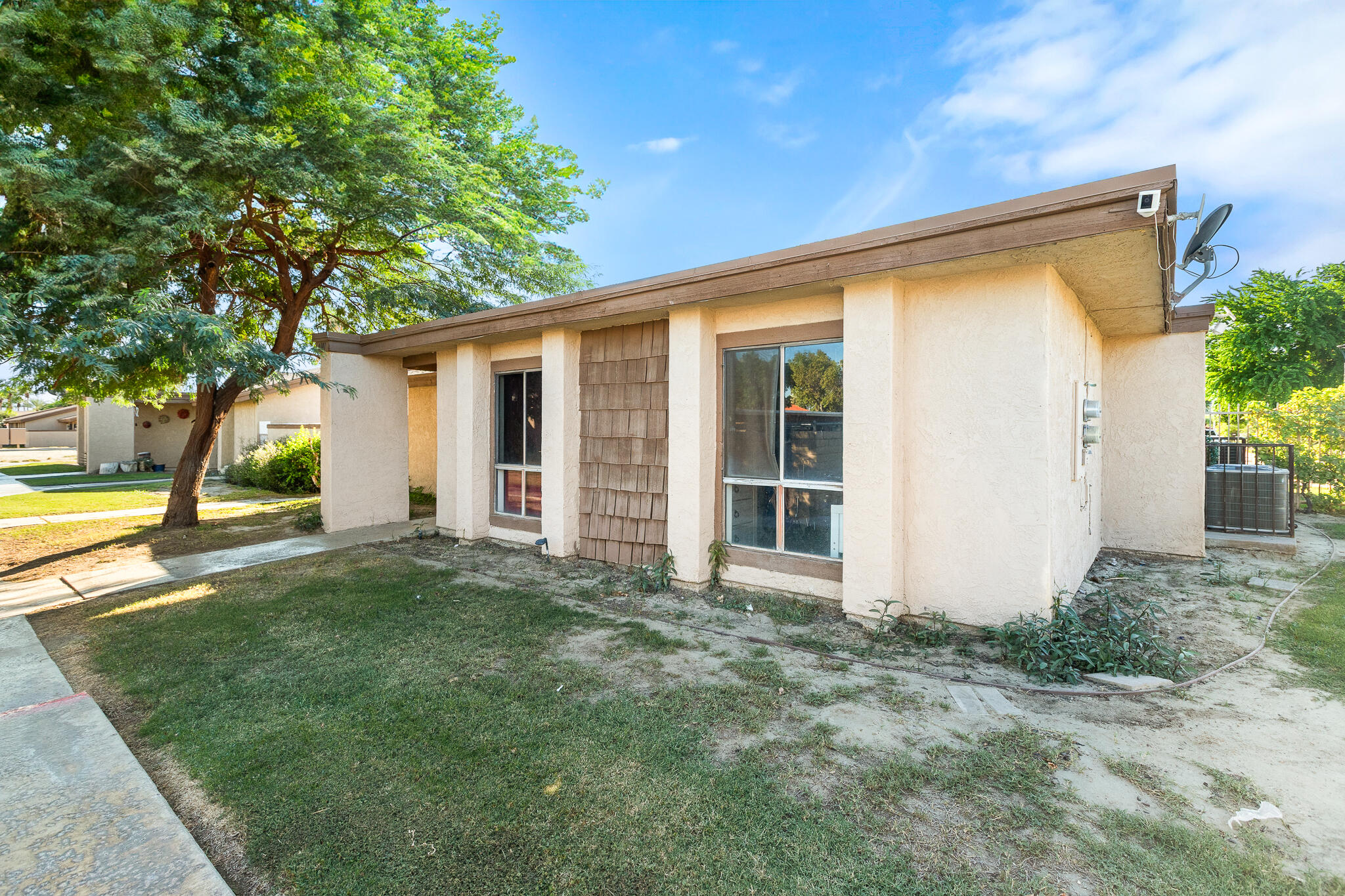 45546 Aladdin Street, Unit A101 Indio, CA 92201 - Photo 9 of 22 front view of a house with a big yard