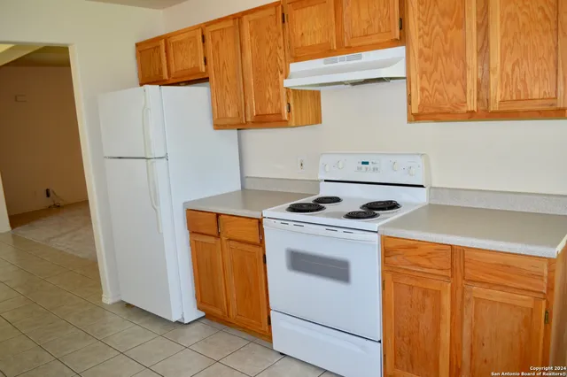 a kitchen with stainless steel appliances white cabinets and a refrigerator