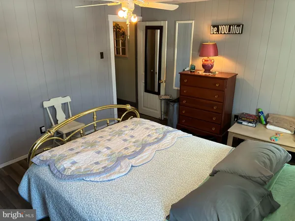 a bedroom with a bed and dresser with mirror