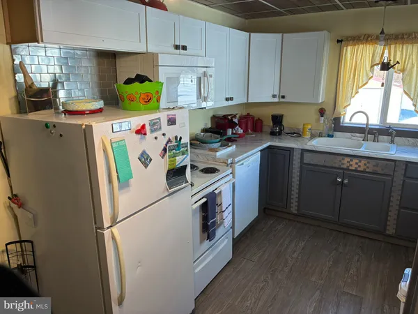 a kitchen with a white refrigerator a sink a stove and cabinets
