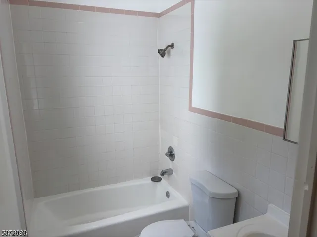 a white bath tub sitting next to a toilet