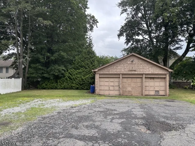 a view of yellow house with a big yard and large trees