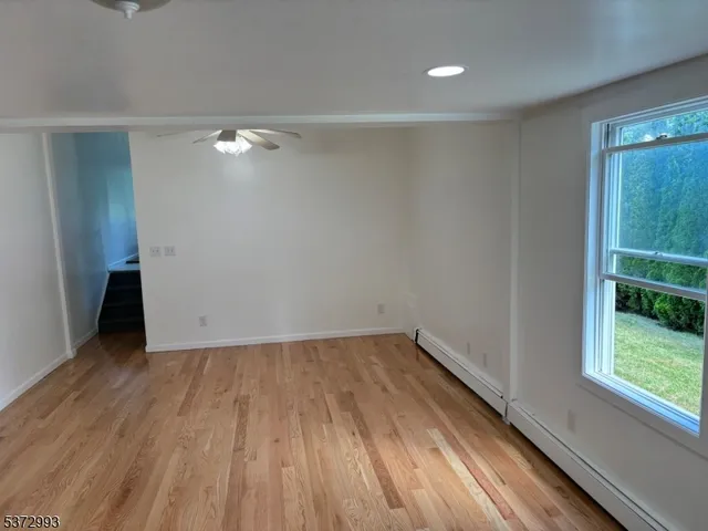 a view of room with window and wooden floor